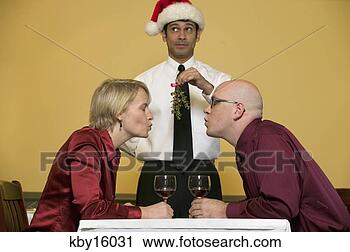 Stock Photography - waiter holding 
mistletoe for 
kissing couple. 
fotosearch - search 
stock photos, 
pictures, images, 
and photo clipart