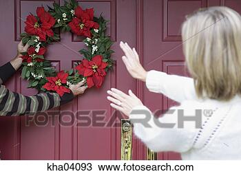 Stock Photo - woman directing 
person hanging 
christmas wreath. 
fotosearch - search 
stock photos, 
pictures, images, 
and photo clipart