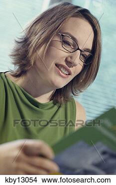 Stock Photo - woman examining 
booklet. fotosearch 
- search stock 
photos, pictures, 
images, and photo 
clipart