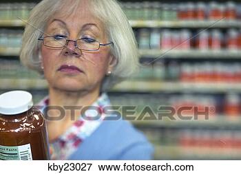 Picture - woman examining 
jar in store. 
fotosearch - search 
stock photos, 
pictures, images, 
and photo clipart
