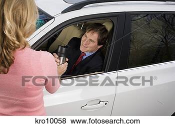 Stock Photo - woman giving coffee 
to husband in 
car. fotosearch 
- search stock 
photos, pictures, 
images, and photo 
clipart
