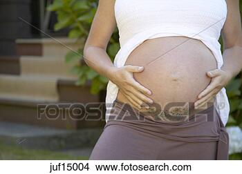 Stock Photo - woman holding 
her tattooed pregnant 
stomach. fotosearch 
- search stock 
photos, pictures, 
images, and photo 
clipart