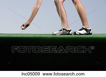 Stock Photograph - woman placing 
golf ball on tee. 
fotosearch - search 
stock photos, 
pictures, images, 
and photo clipart