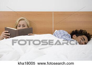 Stock Image - woman reading 
as boyfriend sleeps 
beside her. fotosearch 
- search stock 
photos, pictures, 
images, and photo 
clipart
