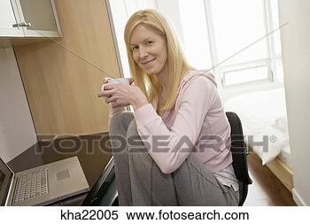 Stock Image - woman sitting 
at desk with laptop. 
fotosearch - search 
stock photos, 
pictures, images, 
and photo clipart