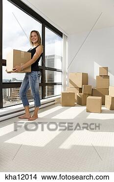 Stock Photo - woman smiling 
and holding moving 
box indoors. fotosearch 
- search stock 
photos, pictures, 
images, and photo 
clipart