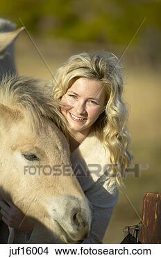 Stock Photo - woman smiling 
and petting foal. 
fotosearch - search 
stock photos, 
pictures, images, 
and photo clipart