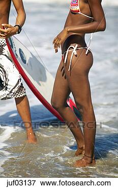 Picture - woman and surfer 
standing in water 
on beach. fotosearch 
- search stock 
photos, pictures, 
images, and photo 
clipart