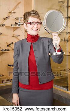 Stock Photo - woman trying on 
eyeglasses. fotosearch 
- search stock 
photos, pictures, 
images, and photo 
clipart