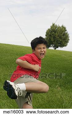 Stock Photo - young asian boy 
kicking outdoors. 
fotosearch - search 
stock photos, 
pictures, images, 
and photo clipart