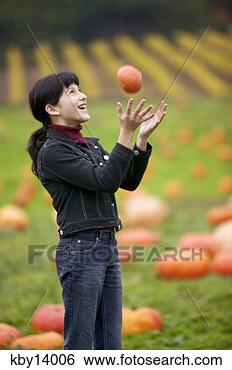 Stock Photo - young girl tossing 
pumpkin in air 
and catching it. 
fotosearch - search 
stock photos, 
pictures, images, 
and photo clipart