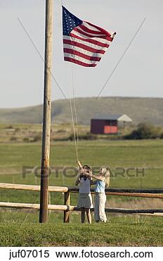Stock Image - young girls raising 
american flag. 
fotosearch - search 
stock photos, 
pictures, images, 
and photo clipart