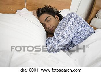 Stock Photography - young hispanic 
man lying in bed 
sleeping. fotosearch 
- search stock 
photos, pictures, 
images, and photo 
clipart