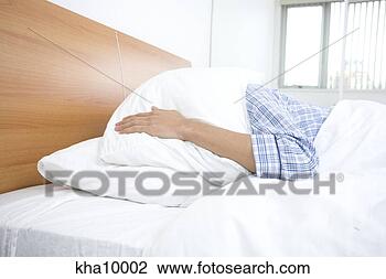 Stock Photo - young man in bed, 
covering head 
pillow. fotosearch 
- search stock 
photos, pictures, 
images, and photo 
clipart