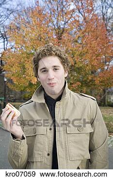 Stock Photograph - young man eating 
a hotdog. fotosearch 
- search stock 
photos, pictures, 
images, and photo 
clipart
