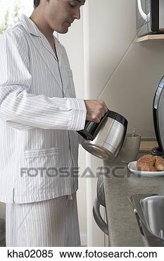 Stock Image - young man making 
breakfast. fotosearch 
- search stock 
photos, pictures, 
images, and photo 
clipart