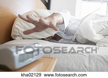 Stock Photograph - young man reaching 
for alarm clock. 
fotosearch - search 
stock photos, 
pictures, images, 
and photo clipart