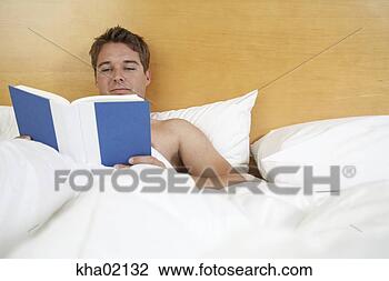 Stock Photo - young man reading 
in bed. fotosearch 
- search stock 
photos, pictures, 
images, and photo 
clipart