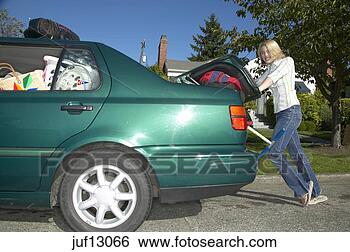 Stock Photo - young woman cramming 
car trunk. fotosearch 
- search stock 
photos, pictures, 
images, and photo 
clipart