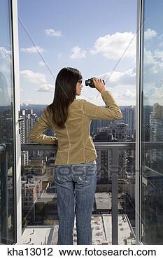 Stock Photo - young woman looking 
through binoculars 
with city skyline. 
fotosearch - search 
stock photos, 
pictures, images, 
and photo clipart