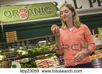 Stock Photograph - young woman shopping 
in organic produce 
aisle in grocery 
store. fotosearch 
- search stock 
photos, pictures, 
images, and photo 
clipart