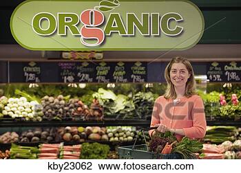 Stock Photo - young woman shopping 
in organic produce 
aisle of grocery 
store. fotosearch 
- search stock 
photos, pictures, 
images, and photo 
clipart