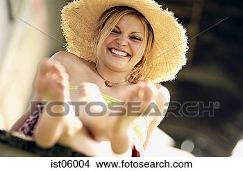Stock Photo - young woman wearing 
straw hat and 
smiling outdoors. 
fotosearch - search 
stock photos, 
pictures, images, 
and photo clipart