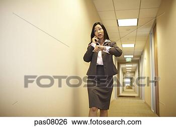 Stock Photo - asian businesswoman 
talking on cell 
phone and checking 
time. fotosearch 
- search stock 
photos, pictures, 
images, and photo 
clipart