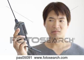 Stock Photography - asian man holding 
a walkie-talkie. 
fotosearch - search 
stock photos, 
pictures, images, 
and photo clipart