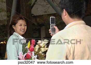 Picture - asian man taking 
asian woman’s 
photograph with 
cell phone. fotosearch 
- search stock 
photos, pictures, 
images, and photo 
clipart