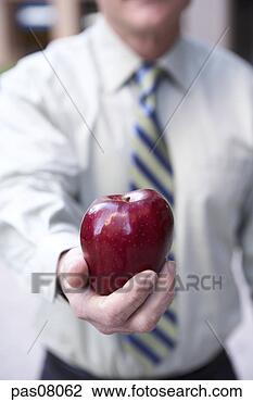 Stock Photo - businessman holding 
apple. fotosearch 
- search stock 
photos, pictures, 
images, and photo 
clipart