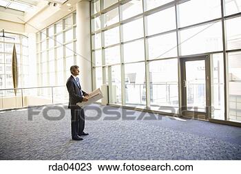 Stock Photo - businessman holding 
blueprints. fotosearch 
- search stock 
photos, pictures, 
images, and photo 
clipart