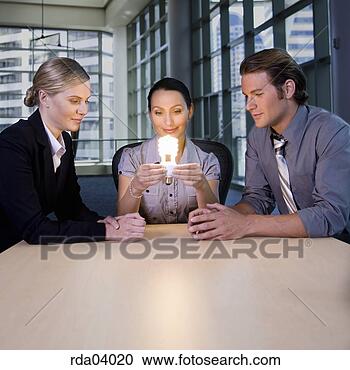 Stock Photography - businesspeople 
looking at energy 
efficient light 
bulb. fotosearch 
- search stock 
photos, pictures, 
images, and photo 
clipart