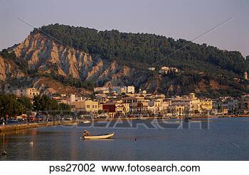 Stock Photo - coastal town on 
hillside with 
man in motor boat 
by buoy. fotosearch 
- search stock 
photos, pictures, 
images, and photo 
clipart