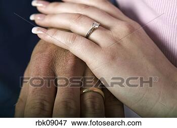 Picture - couple wearing  wedding rings  holding hands.  fotosearch - search  stock photos,  pictures, images,  and photo clipart