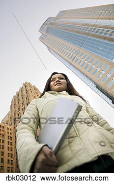 Stock Photo - low angle view 
of asian woman 
carrying folder. 
fotosearch - search 
stock photos, 
pictures, images, 
and photo clipart