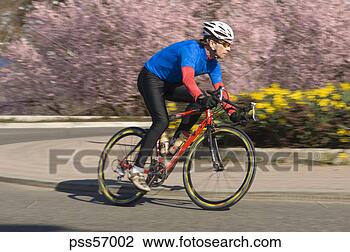 Stock Photo - man cycling on 
rural road. fotosearch 
- search stock 
photos, pictures, 
images, and photo 
clipart