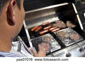 Stock Photo - man grilling hotdogs 
and hamburgers. 
fotosearch - search 
stock photos, 
pictures, images, 
and photo clipart