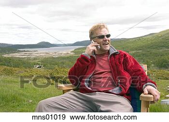 Stock Photograph - man talking on 
cell phone in 
countryside. fotosearch 
- search stock 
photos, pictures, 
images, and photo 
clipart