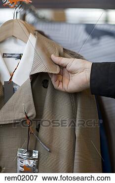 Picture - man touching fabric 
of coat in clothing 
store. fotosearch 
- search stock 
photos, pictures, 
images, and photo 
clipart
