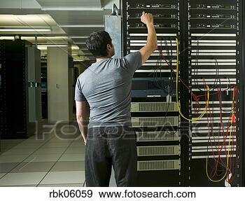 Stock Photograph - man working on 
computer network 
server. fotosearch 
- search stock 
photos, pictures, 
images, and photo 
clipart