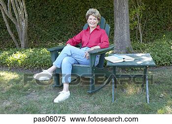 Stock Image - middle-aged woman 
relaxing in backyard. 
fotosearch - search 
stock photos, 
pictures, images, 
and photo clipart