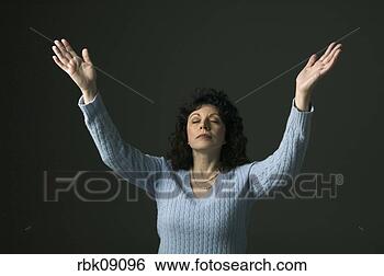Stock Photo - middle aged woman 
praying with arms 
lifted. fotosearch 
- search stock 
photos, pictures, 
images, and photo 
clipart
