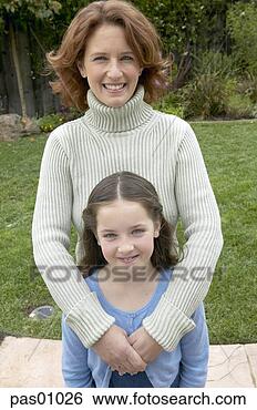 Stock Photo - mother and daughter 
standing in backyard. 
fotosearch - search 
stock photos, 
pictures, images, 
and photo clipart