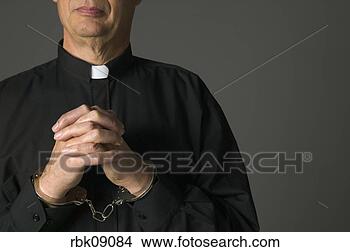 Stock Photo - priest in handcuffs 
praying. fotosearch 
- search stock 
photos, pictures, 
images, and photo 
clipart