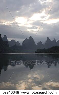 Stock Photo - scenic view of 
mountains and 
body of water 
at sunrise. fotosearch 
- search stock 
photos, pictures, 
images, and photo 
clipart
