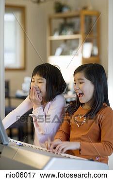 Picture - sisters playing 
a keyboard together. 
fotosearch - search 
stock photos, 
pictures, images, 
and photo clipart