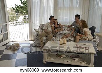 Stock Photograph - two couples using 
playing cards 
on sofa. fotosearch 
- search stock 
photos, pictures, 
images, and photo 
clipart