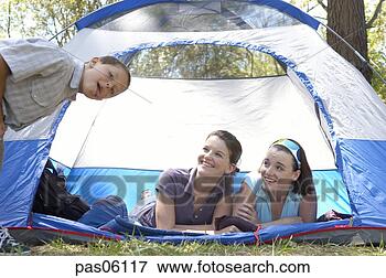 Picture - two sisters in 
a tent smiling 
at their brother. 
fotosearch - search 
stock photos, 
pictures, images, 
and photo clipart