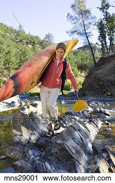 Stock Photography - woman carrying 
kayak across craggy 
stream. fotosearch 
- search stock 
photos, pictures, 
images, and photo 
clipart